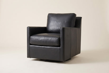 Elwood swivel glider chair in Black leather, three-quarter view on a warm off-white studio backdrop: straight track arms