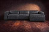 The Emery sectional in Aged Slate distressed leather seen from the front on a dark walnut herringbone floor, headrests down and footrest closed. Shown in Aged Slate, Right chaise.
