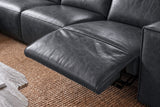 Close-up of an Emery recliner beside its box arm, the one-piece footrest out over its black steel mechanism and the closed seat beside it in line, on a woven jute rug. Shown in Aged Slate.