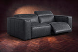 The Emery loveseat in Aged Slate on a dark herringbone floor, the right-hand recliner open with its one-piece footrest out and its headrest raised. Shown in Aged Slate, Loveseat.