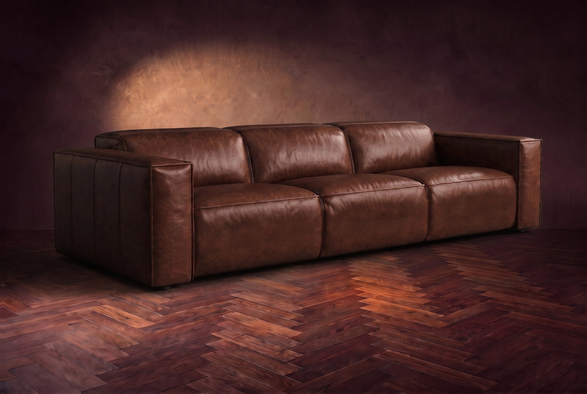 The Emery 3 seat in Burnished Chestnut distressed full leather on a dark herringbone floor, headrests down and footrests closed. Shown in Burnished Chestnut, 3 seat.