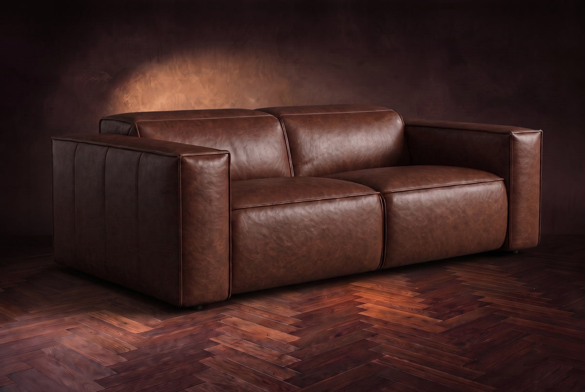 The Emery loveseat in Burnished Chestnut distressed full leather on a dark herringbone floor, headrests down and footrests closed. Shown in Burnished Chestnut, Loveseat.