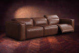 The Emery 3 seat in Burnished Chestnut on a dark herringbone floor, the right-hand recliner open with its one-piece footrest out and its headrest raised. Shown in Burnished Chestnut, 3 seat.