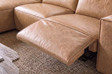 Close-up of an Emery recliner beside its box arm, the one-piece footrest out over its black steel mechanism and the closed seat beside it in line, on a woven jute rug. Shown in Washed Sand.