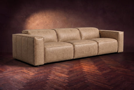 The Emery 3 seat in Washed Sand distressed full leather on a dark herringbone floor, headrests down and footrests closed. Shown in Washed Sand, 3 seat.