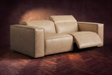 The Emery loveseat in Washed Sand on a dark herringbone floor, the right-hand recliner open with its one-piece footrest out and its headrest raised. Shown in Washed Sand, Loveseat.