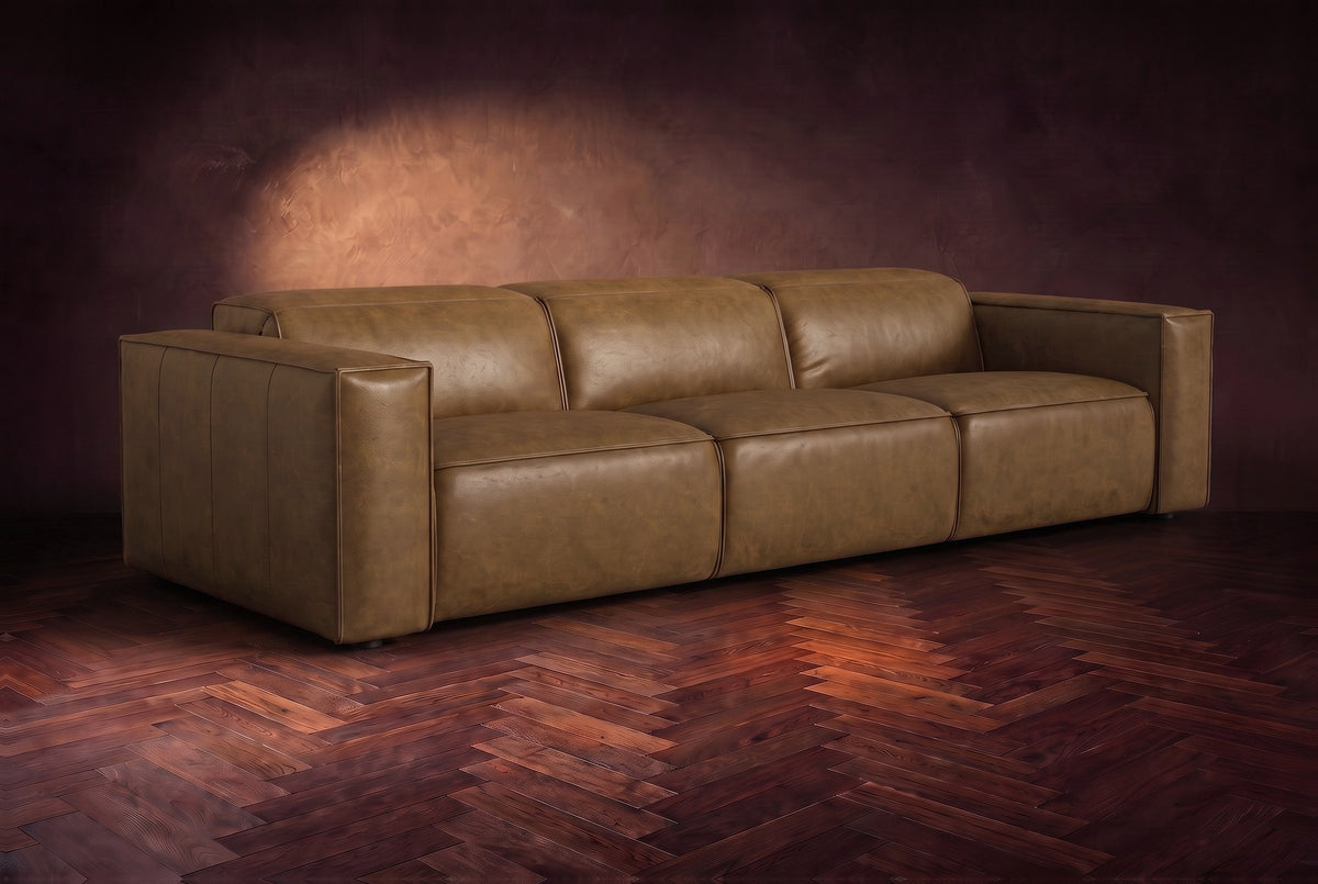 The Emery 3 seat in Weathered Saddle distressed full leather on a dark herringbone floor, headrests down and footrests closed. Shown in Weathered Saddle, 3 seat.