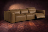 The Emery 3 seat in Weathered Saddle on a dark herringbone floor, the right-hand recliner open with its one-piece footrest out and its headrest raised. Shown in Weathered Saddle, 3 seat.