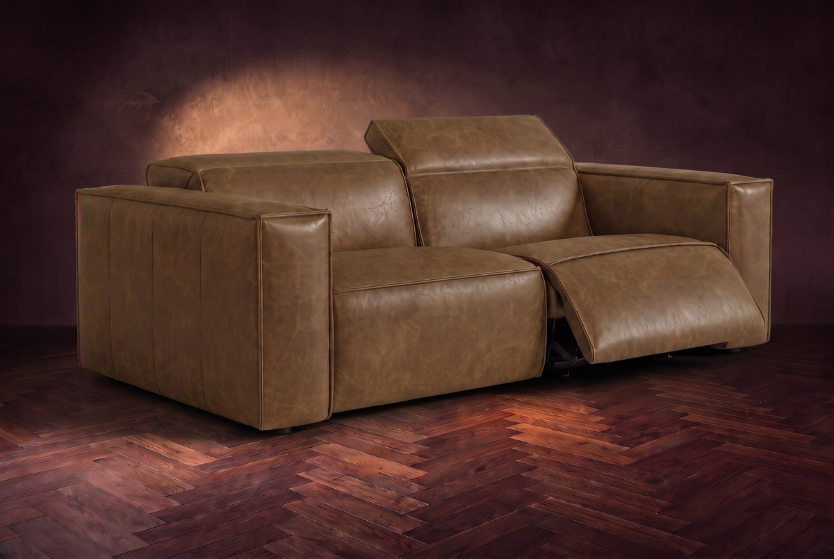The Emery loveseat in Weathered Saddle on a dark herringbone floor, the right-hand recliner open with its one-piece footrest out and its headrest raised. Shown in Weathered Saddle, Loveseat.