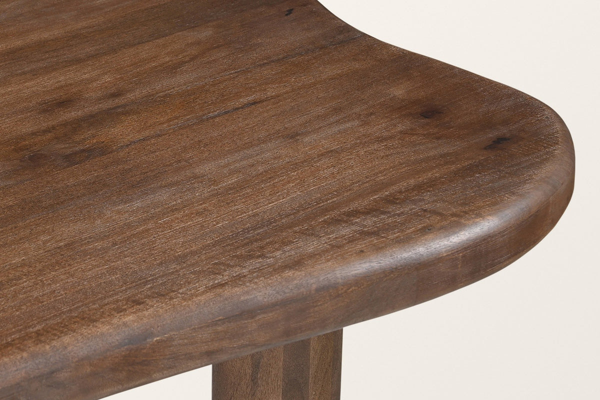 Close-up of the Erbusco top: the fully rounded edge of the solid mango top at its broad end, dark walnut finish