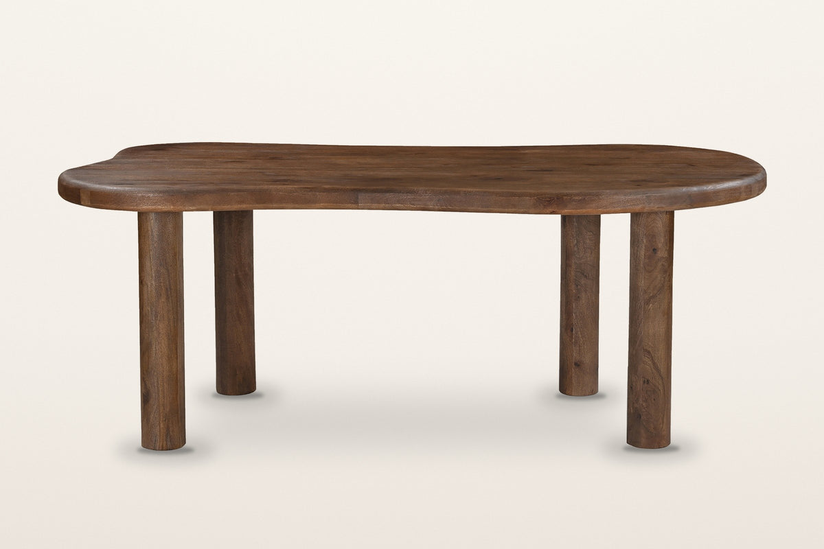 Erbusco dining table in dark walnut from the long side: a freeform top with a thick rounded edge on four round post legs