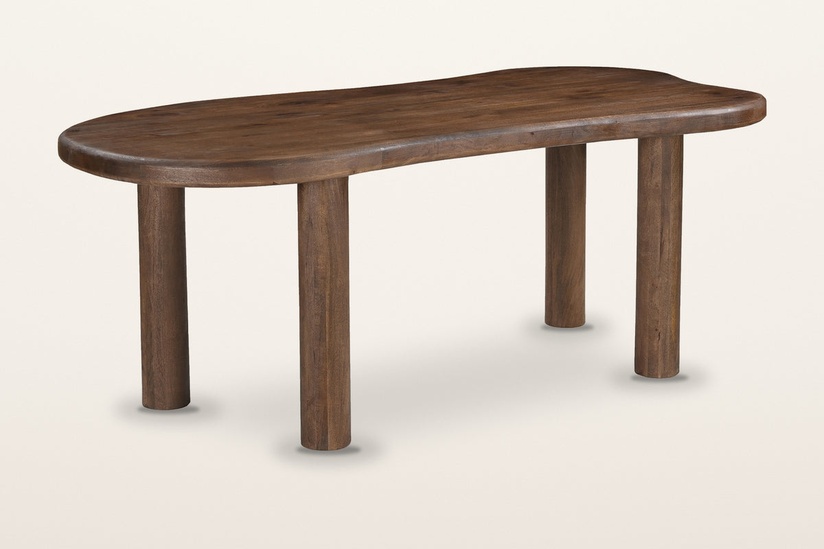 Erbusco freeform mango wood dining table in dark walnut, three-quarter view on a warm white studio backdrop