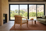 Esanatoglia accent chair seen from behind in a Keremeos orchard house, the open cane back to the camera