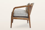 Esanatoglia accent chair from the side on a warm white studio backdrop: the band sloping down to the front leg