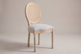 Este oval-back dining chair in limed natural wood with a light grey seat, three-quarter view on a warm grey studio backdrop