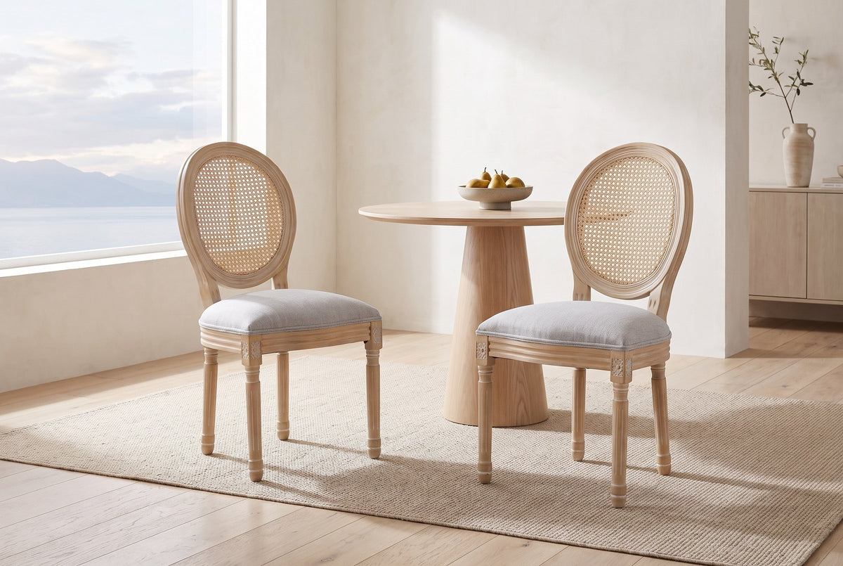 Two Este dining chairs in a bright Vancouver dining nook with a round oak table, a bowl of pears and a window onto the water