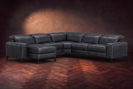 The Esther sectional in Aged Slate distressed full leather on a dark herringbone floor, headrests down and footrest closed. Shown in Aged Slate, Left chaise.