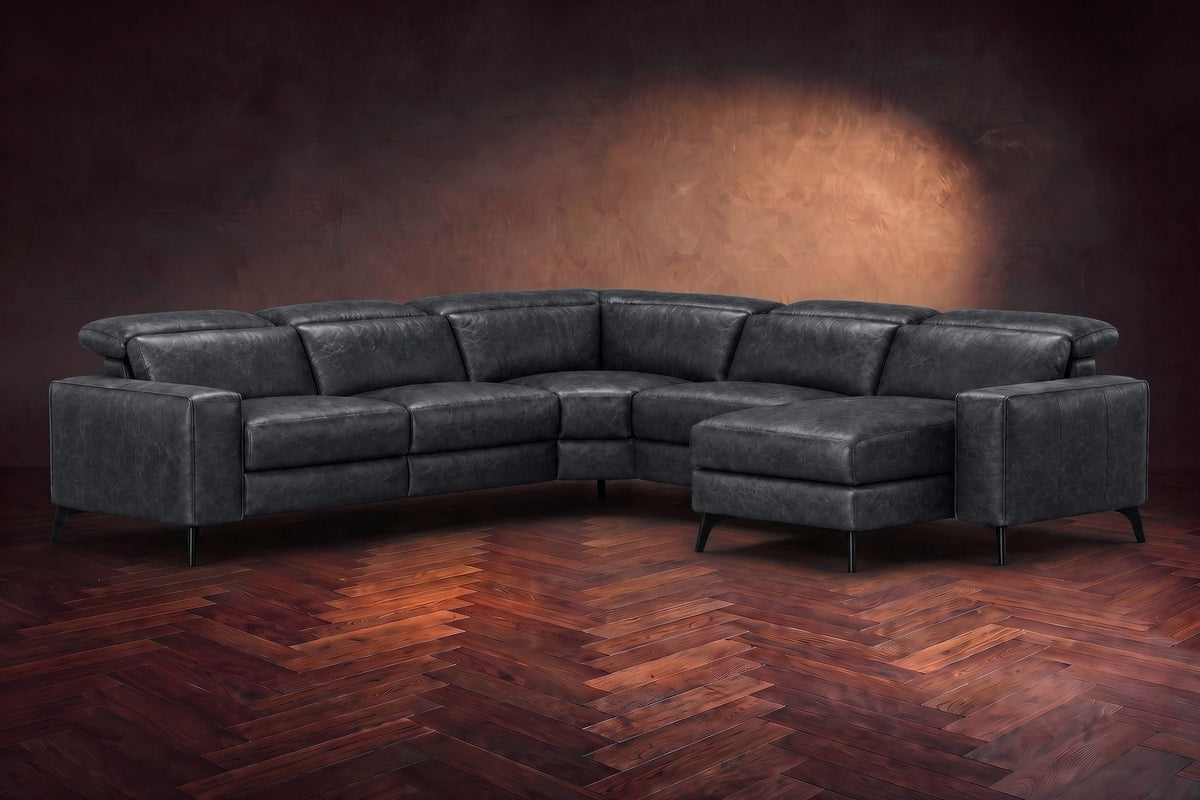 The Esther sectional in Aged Slate distressed full leather on a dark herringbone floor, headrests down and footrest closed. Shown in Aged Slate, Right chaise.