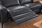 The open Esther recliner in Aged Slate beside its box arm, the one-piece footrest out over a jute rug, a cushion and a knit throw on the next seat. Shown in Aged Slate, Right chaise.