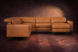 The Esther sectional seen from the front in Antiqued Caramel distressed full leather on a dark herringbone floor, the chaise facing the camera and the footrest closed. Shown in Antiqued Caramel, Right chaise.