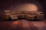 The Esther sectional in Burnished Chestnut distressed full leather on a dark herringbone floor, the power recliner at the arm end open with its one-piece footrest out and its headrest raised. Shown in Burnished Chestnut, Right chaise.