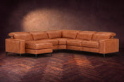 The Esther sectional in Tuscan Cognac distressed full leather on a dark herringbone floor, headrests down and footrest closed. Shown in Tuscan Cognac, Left chaise.