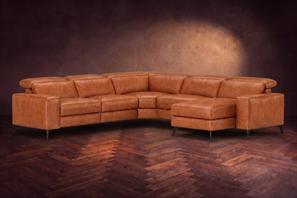 The Esther sectional in Tuscan Cognac distressed full leather on a dark herringbone floor, headrests down and footrest closed. Shown in Tuscan Cognac, Right chaise.