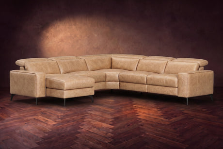 The Esther sectional in Washed Sand distressed full leather on a dark herringbone floor, headrests down and footrest closed. Shown in Washed Sand, Left chaise.