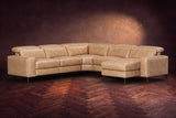 The Esther sectional in Washed Sand distressed full leather on a dark herringbone floor, headrests down and footrest closed. Shown in Washed Sand, Right chaise.