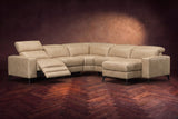 The Esther sectional in Washed Sand distressed full leather on a dark herringbone floor, the power recliner at the arm end open with its one-piece footrest out and its headrest raised. Shown in Washed Sand, Right chaise.
