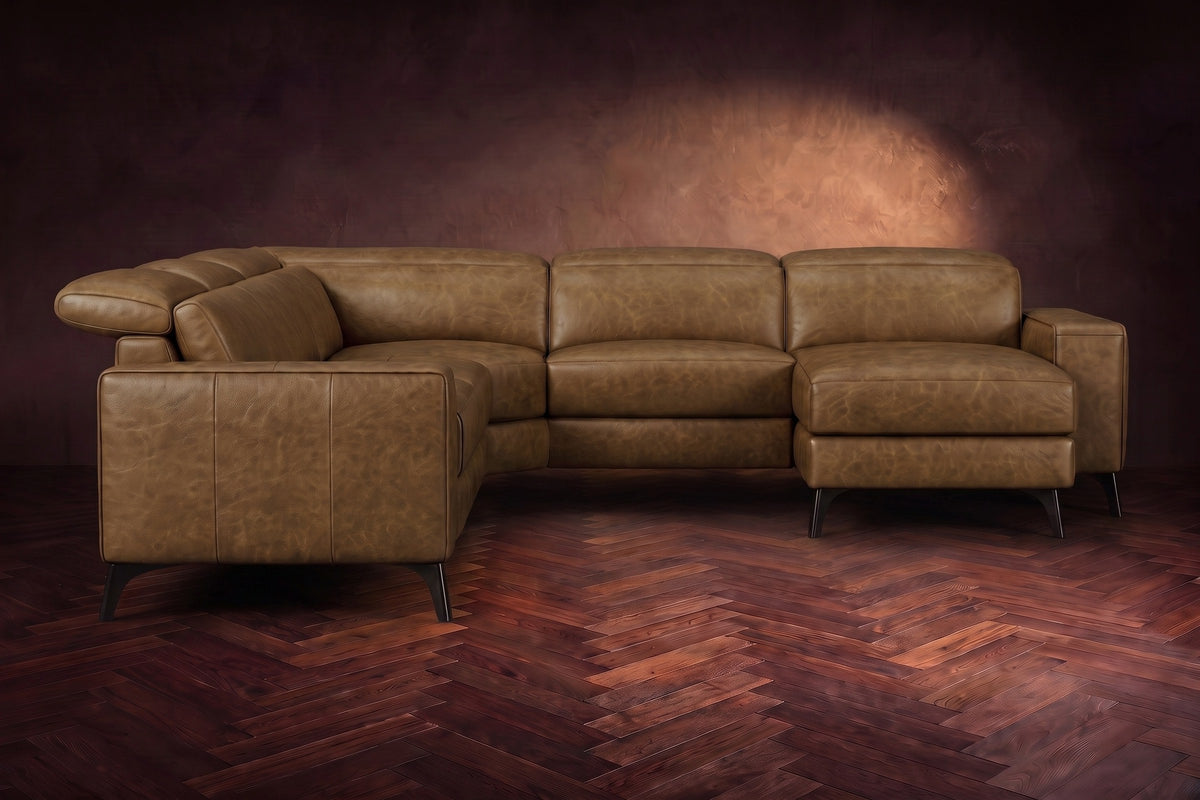 The Esther sectional seen from the front in Weathered Saddle distressed full leather on a dark herringbone floor, the chaise facing the camera and the footrest closed. Shown in Weathered Saddle, Right chaise.