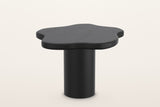 Exilles small cloud table in black, 27 in across and 19 in high on a slim round drum, on a warm white studio backdrop