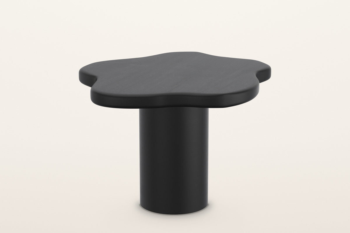 Exilles small cloud table in black, 27 in across and 19 in high on a slim round drum, on a warm white studio backdrop