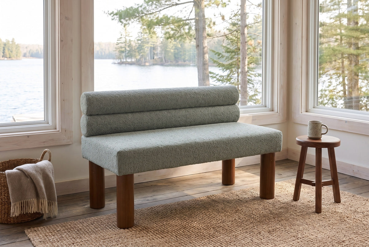 Fabriano bench in a lakeside cottage sunroom with a jute rug, a walnut stool and a view of the water and pines