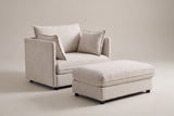 Faenza chair-and-a-half in beige chenille with its storage ottoman, three-quarter view on a warm grey studio backdrop