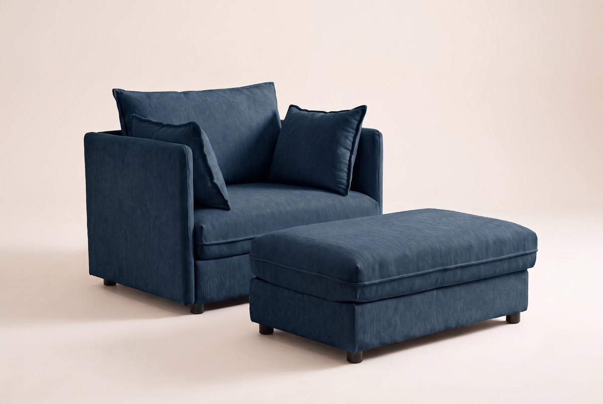 Faenza chair-and-a-half in blue chenille with its storage ottoman, three-quarter view on a warm off-white backdrop