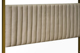 Close-up of the channelled beige headboard held between two gold posts