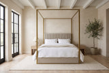Fermo canopy bed made up with white bedding in a loft bedroom with tall black-framed windows and an olive tree