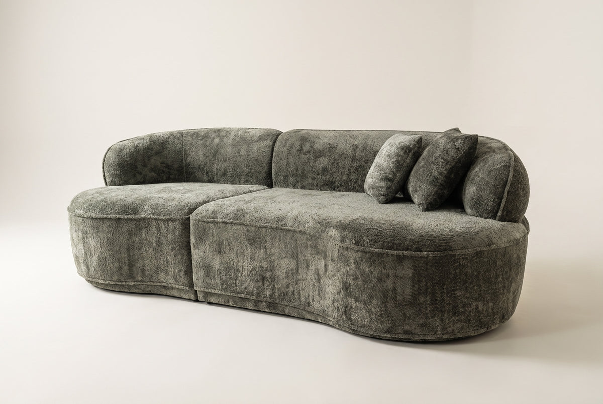 Close-up of a rounded end of the Fiora sofa in Green with its pillows