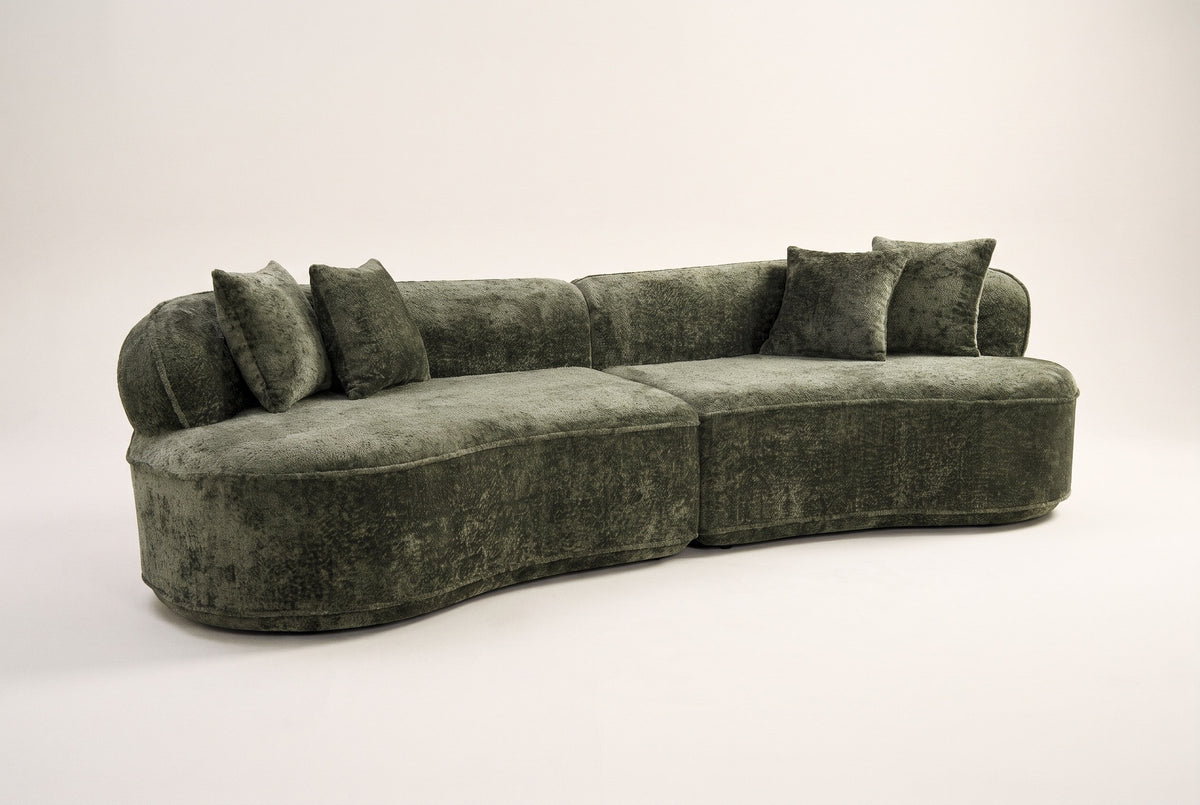 The Fiora curved sofa in Green, front three-quarter view, on an off-white studio background