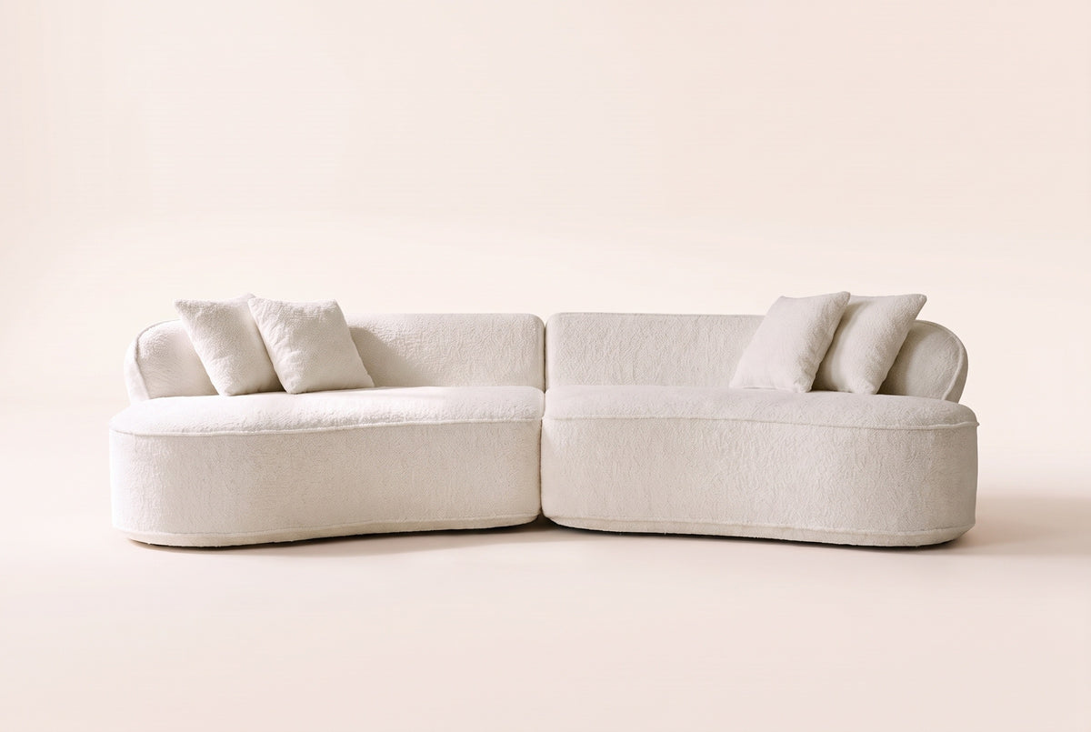 The Fiora curved sofa in White seen straight on, showing its curve and the two pieces