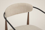 Close-up of the oval back pad, the black steel rail curving behind it and the bronze legs