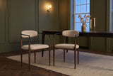 Two Fiuggi chairs in an olive-green Toronto dining room in the evening, a dark table and lit candles behind them