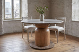 Fiumalbo dining table with two pale whitewashed chairs in a limewashed stone dining room in Quebec City