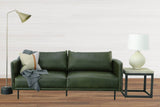 Florence ceramic lamp on a black metal side table beside a green leather sofa
