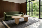 Frontino coffee table in Biscotti Oak seen from above before a moss-green velvet sofa in an Uxbridge forest house