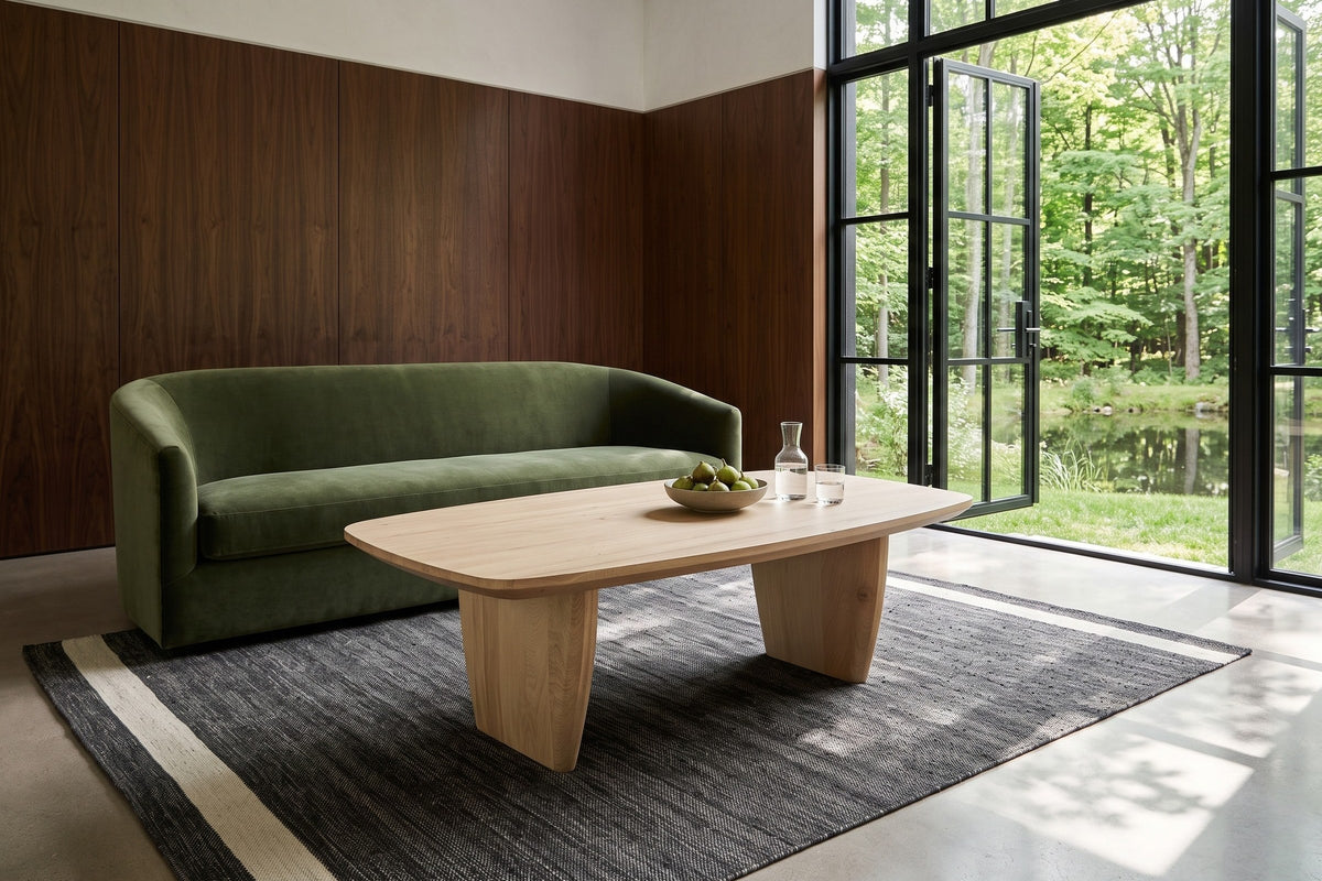 Frontino coffee table in Biscotti Oak seen from above before a moss-green velvet sofa in an Uxbridge forest house