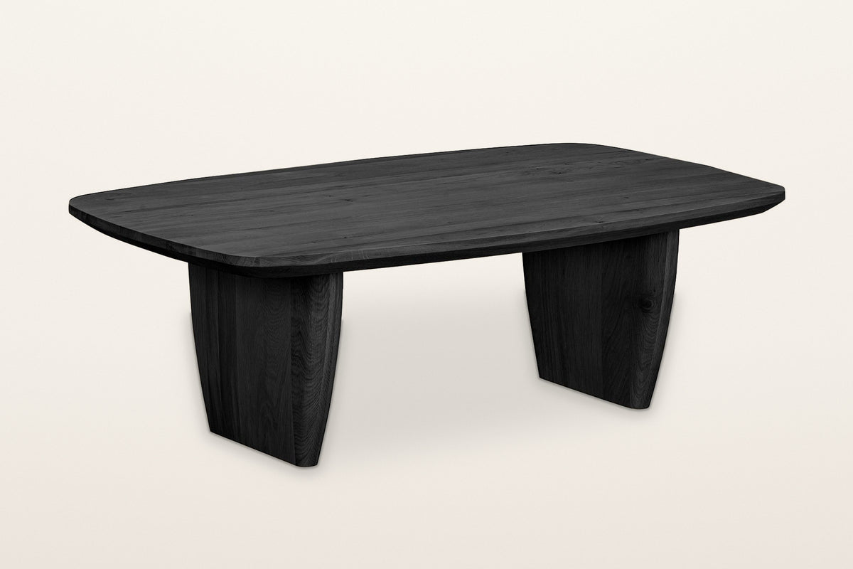 Frontino oak coffee table in Black, three-quarter view on a warm white studio backdrop: a soft boat-shaped top on two slab le