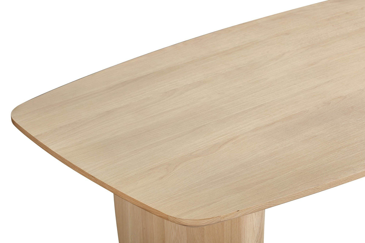 Close-up of a Frontino corner in Biscotti Oak: the rounded corner, the slim bevelled edge and the slab leg below