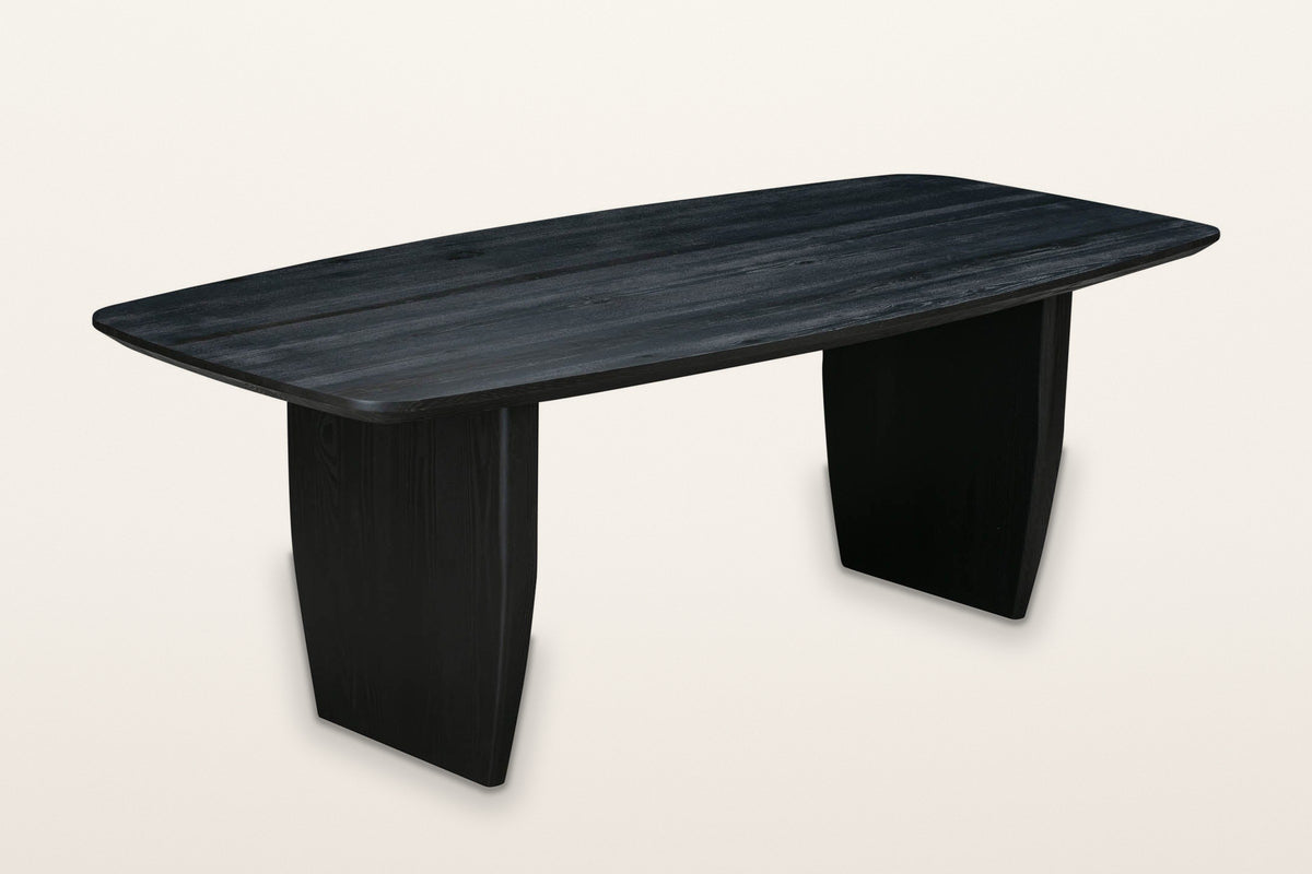 Frontino slab-leg oak dining table in Black, three-quarter view on a warm white studio backdrop